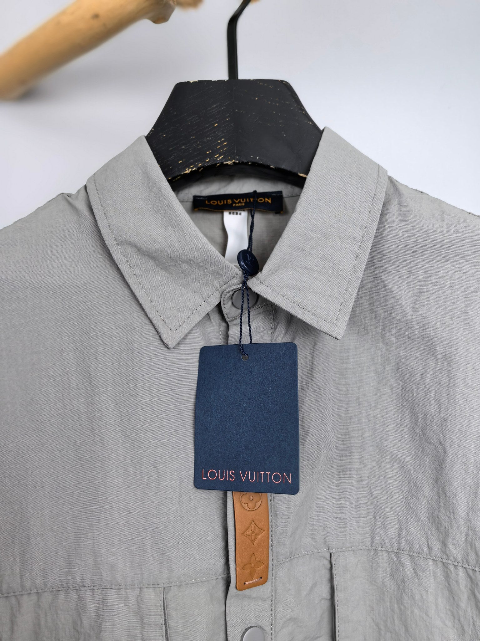 Gray jacket collar with button placket and hanging brand tag