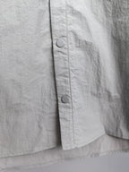 Gray jacket front panel with two visible metal snaps