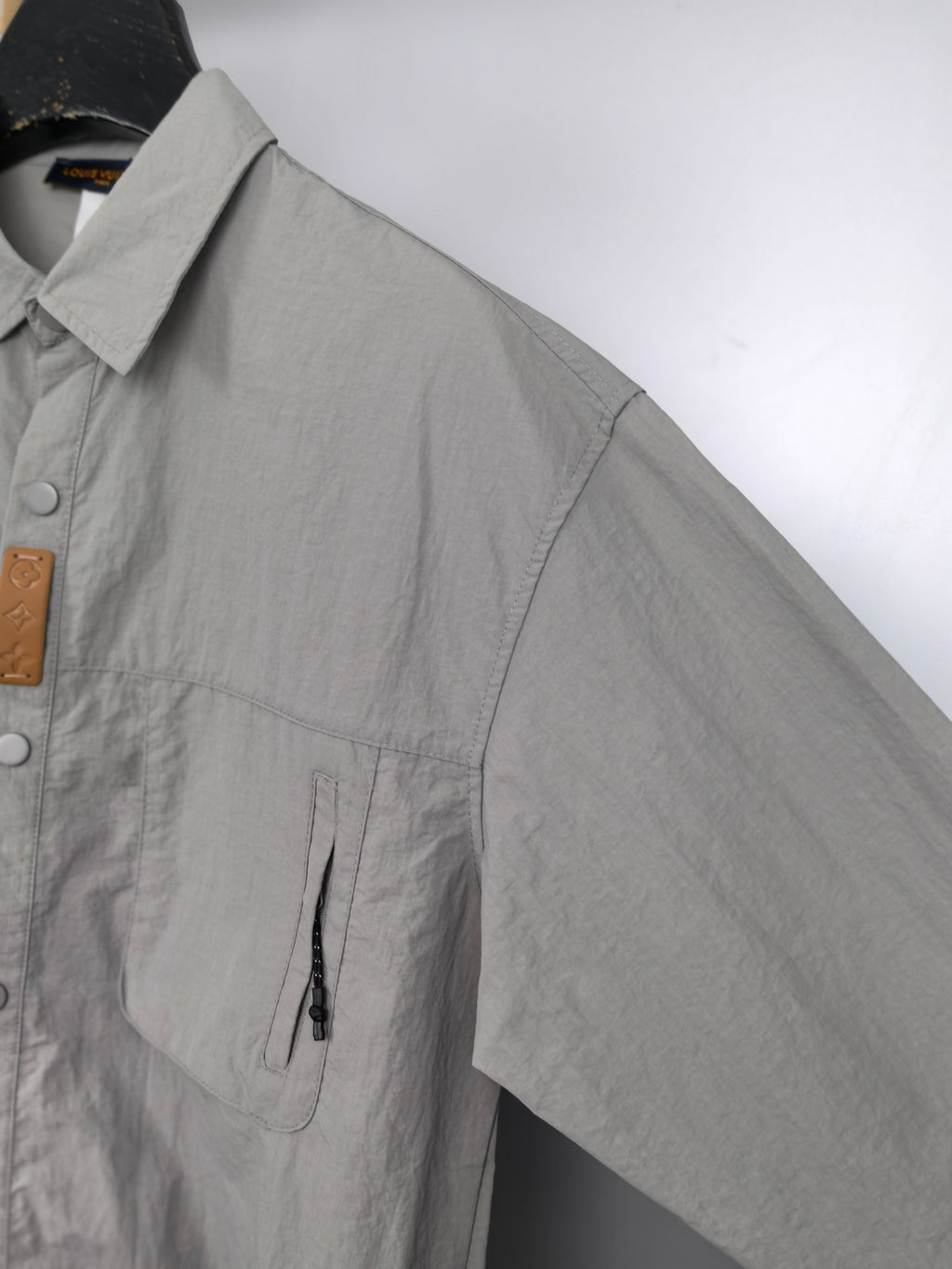 Gray jacket with chest patch pocket and black drawcord detail