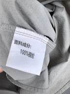 Gray jacket interior label showing "100% cotton" and care text