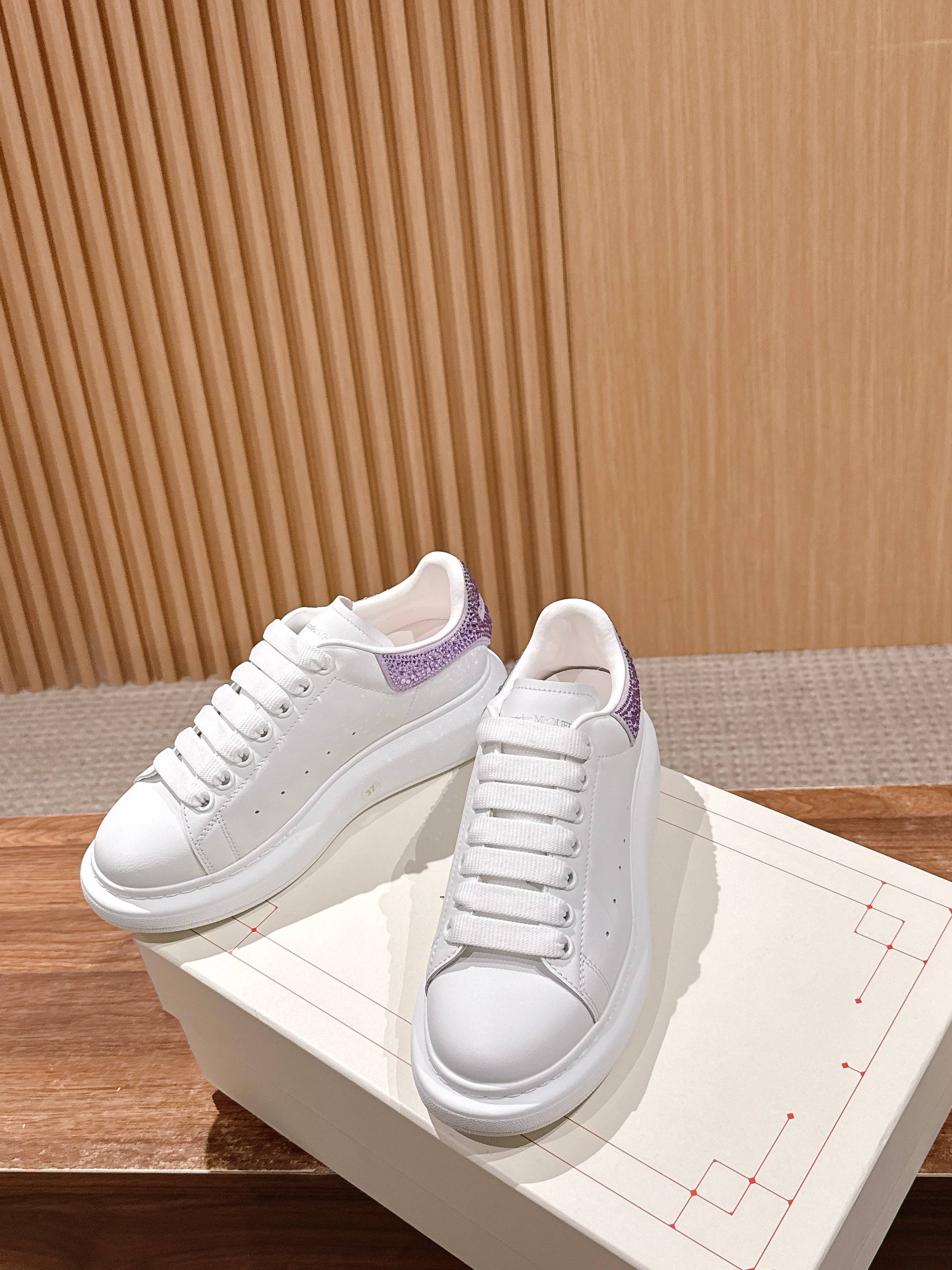 White lace-up sneakers with purple trim at the collar on white midsoles