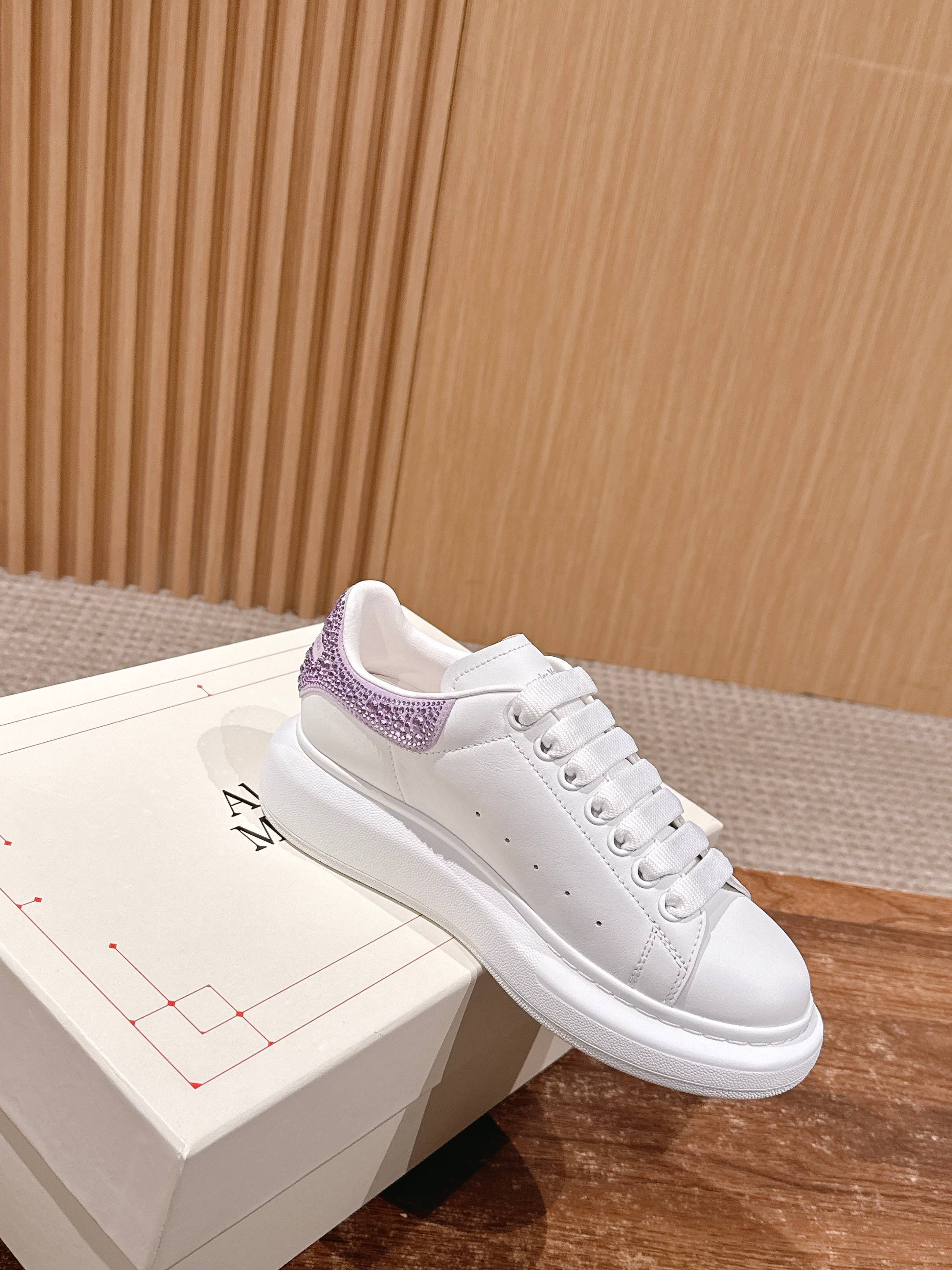 White low-top sneakers with purple glitter collar and lace-up closure