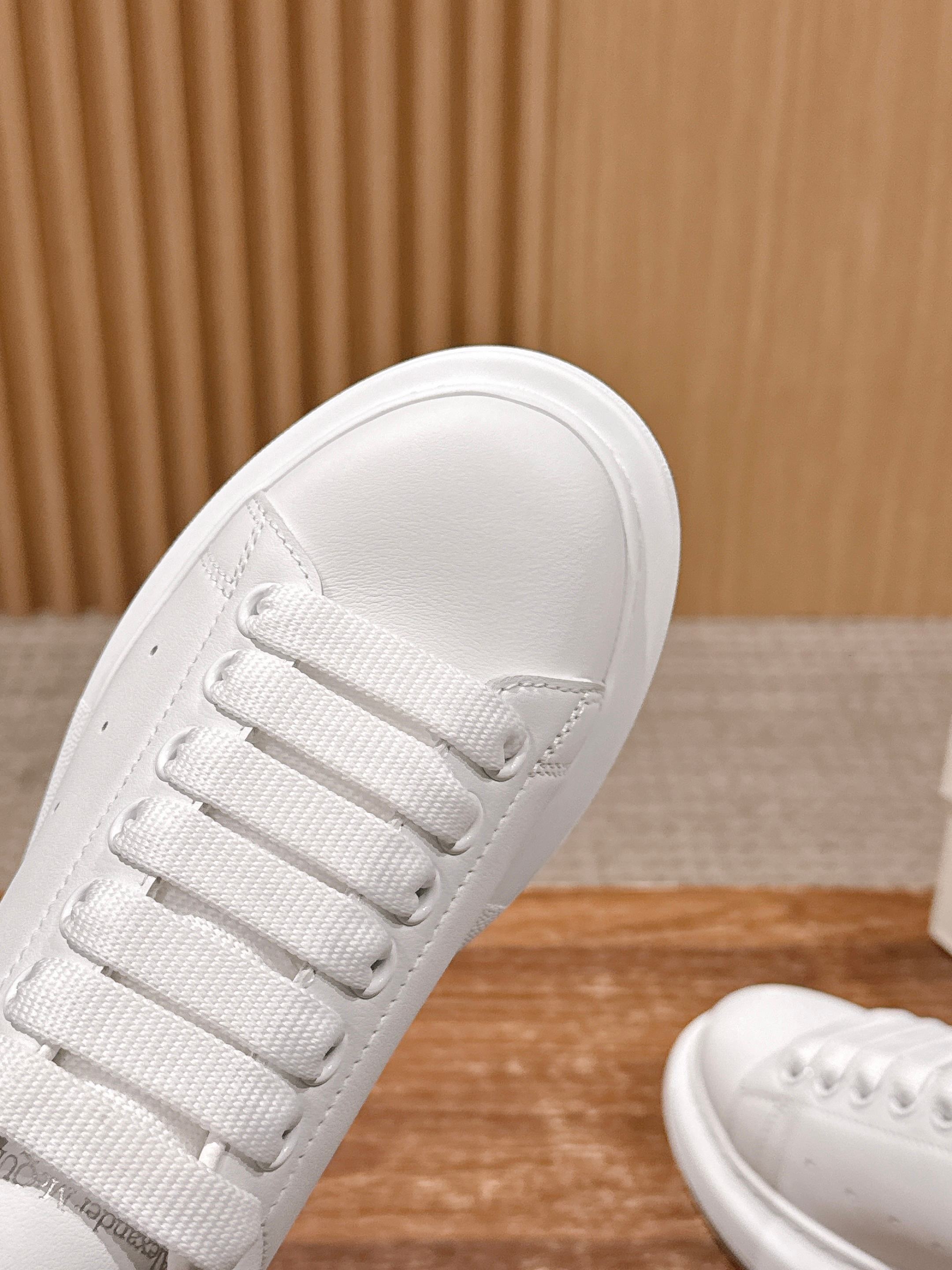 White sneaker toe cap with lace eyelets and smooth textured leather upper