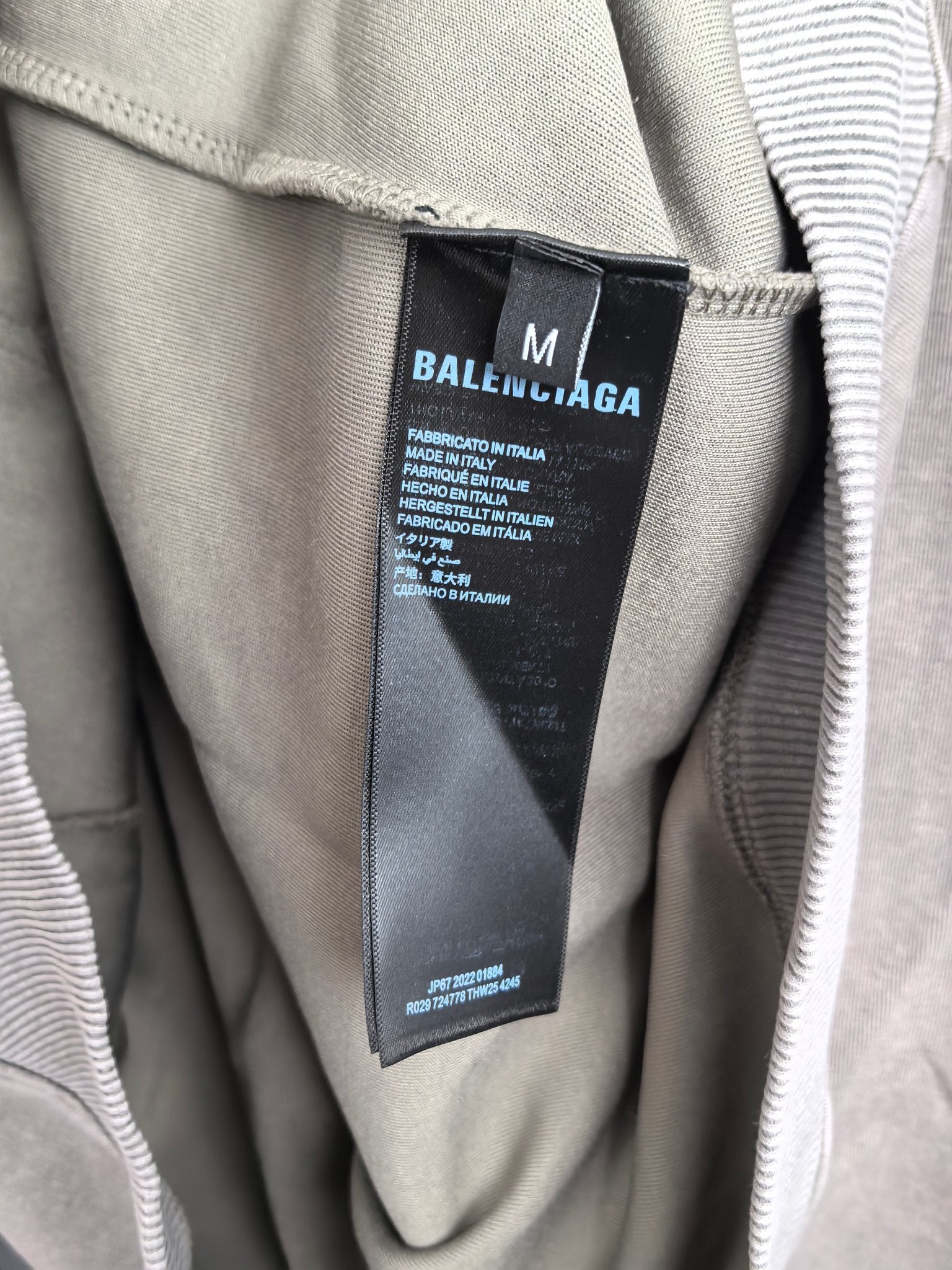 Gray hoodie inside neck showing black brand care label tag