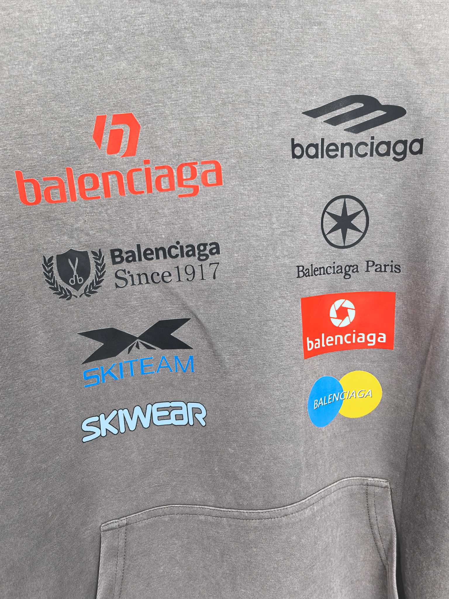Gray hoodie chest with logo prints including Balenciaga and SKWEAR