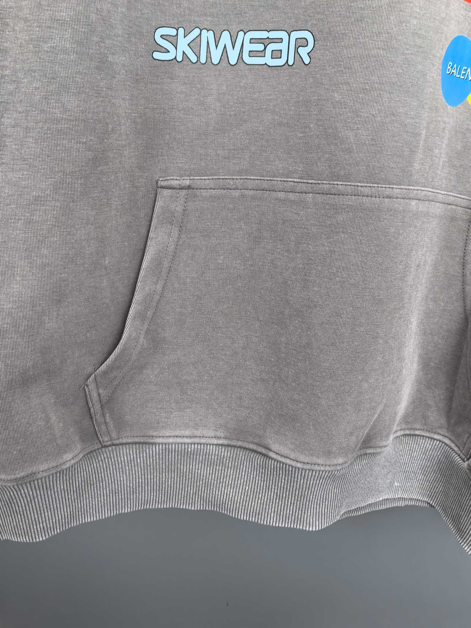 Gray hoodie front pouch pocket with SKWEAR logo above the hem