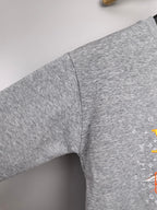 Gray long-sleeve sweatshirt sleeve with side seam and partial graphic print