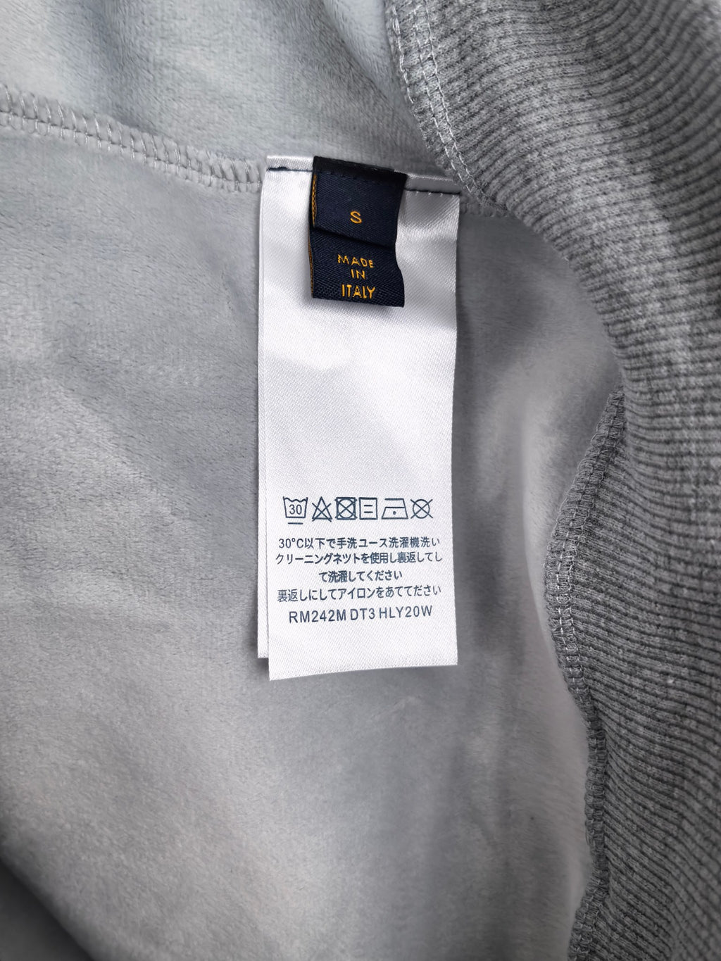 Interior neck label on gray sweatshirt with care information tag