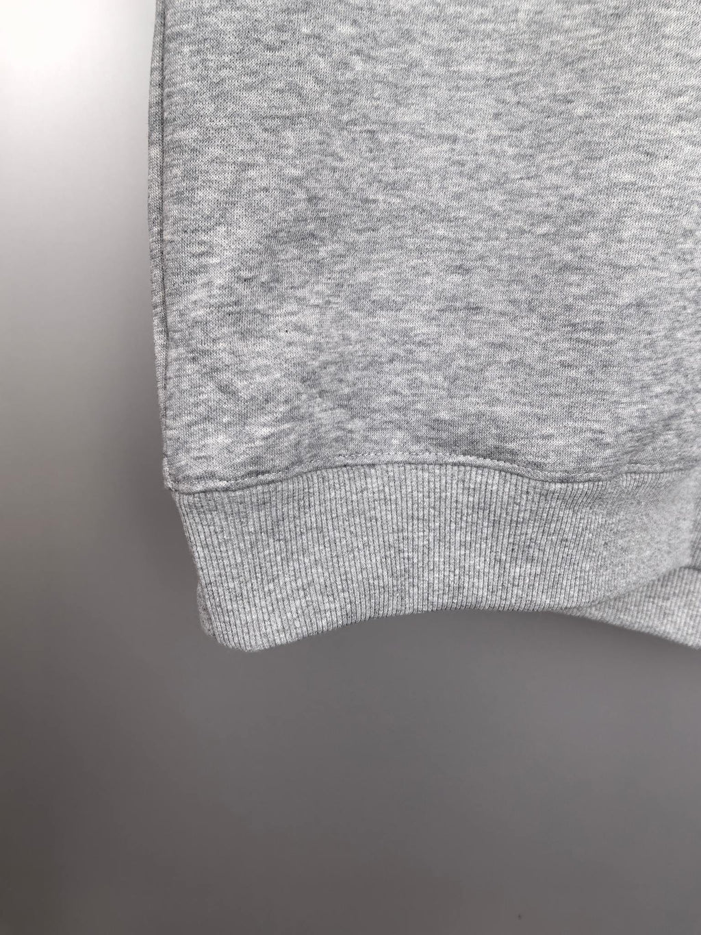 Gray sweatshirt hem with ribbed cuff detail at the sleeve