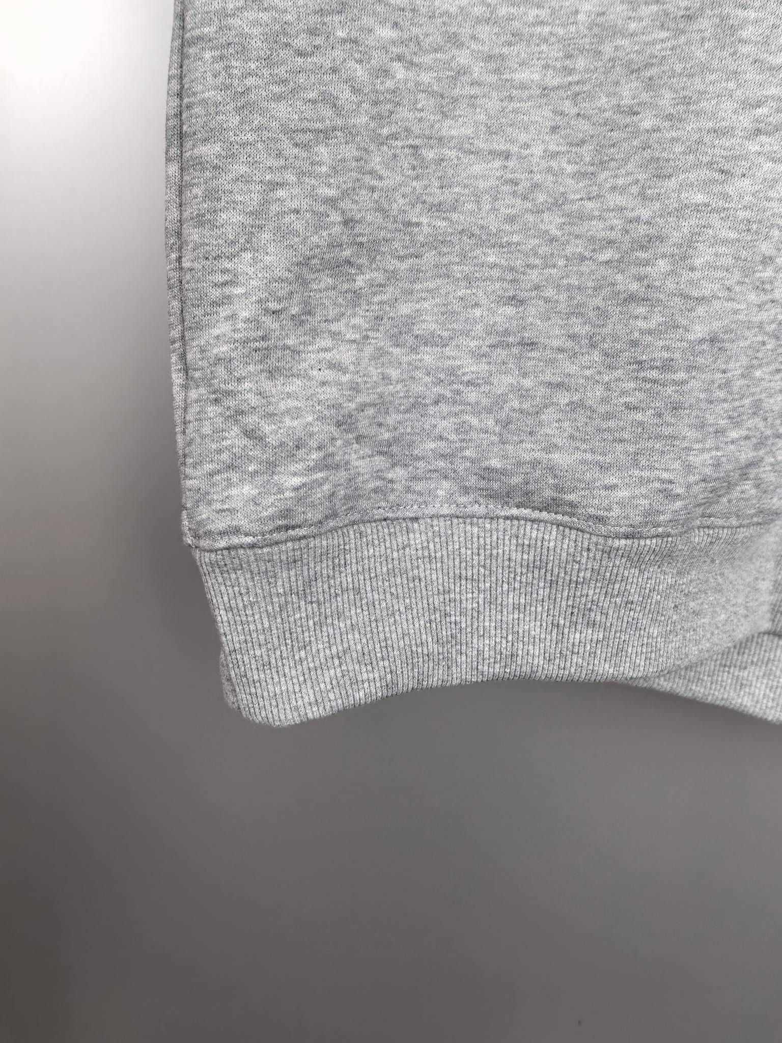 Gray sweatshirt hem with ribbed cuff detail at the sleeve