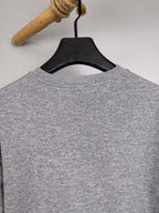 Gray long-sleeve sweatshirt from the back on a hanger, crew neckline