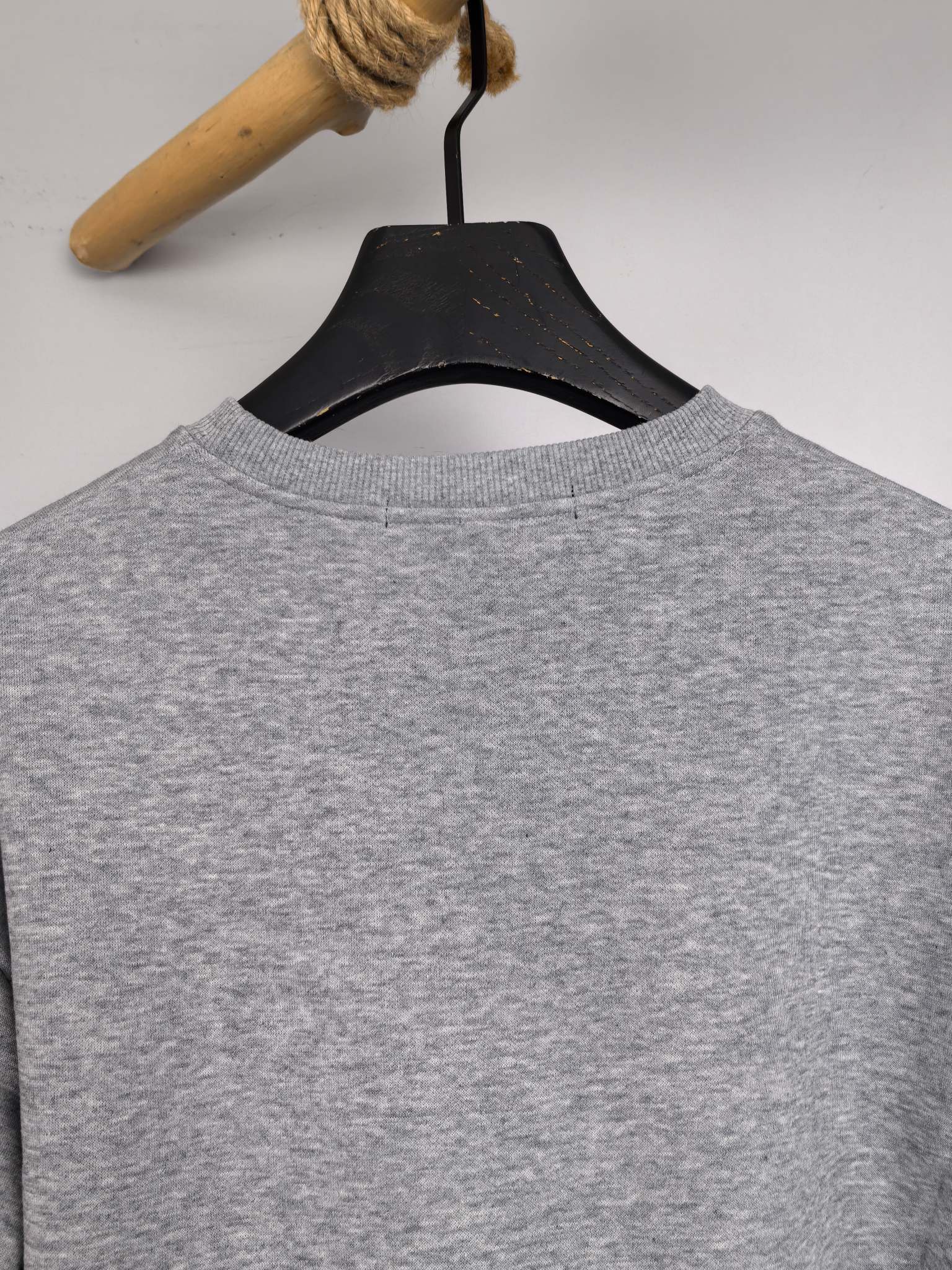 Gray long-sleeve sweatshirt from the back on a hanger, crew neckline