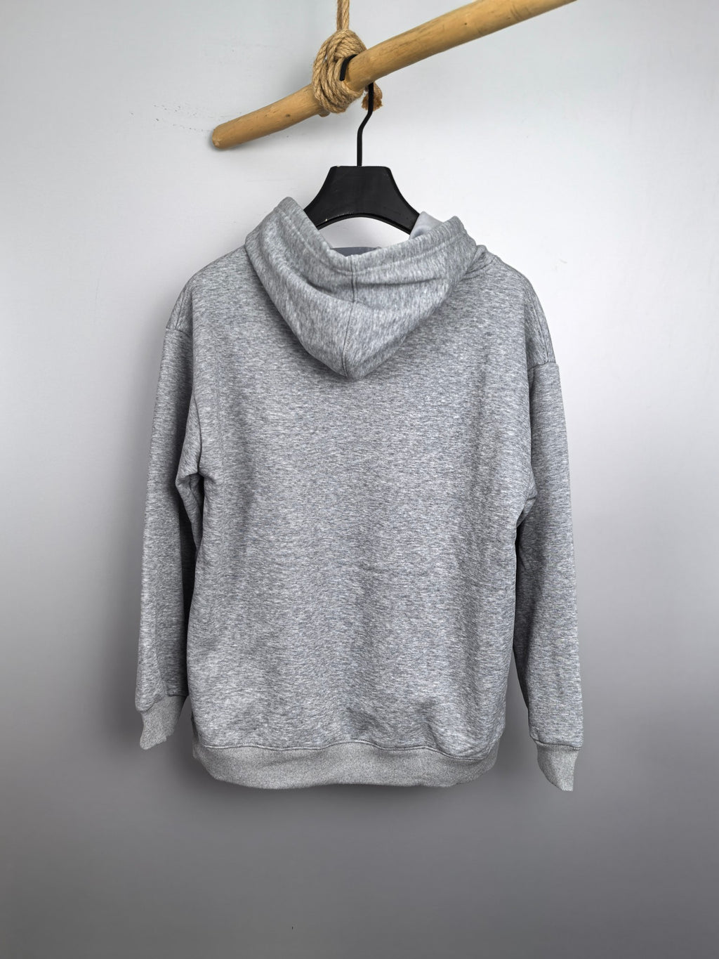 Gray kids pullover hoodie on a hanger with hood and long sleeves