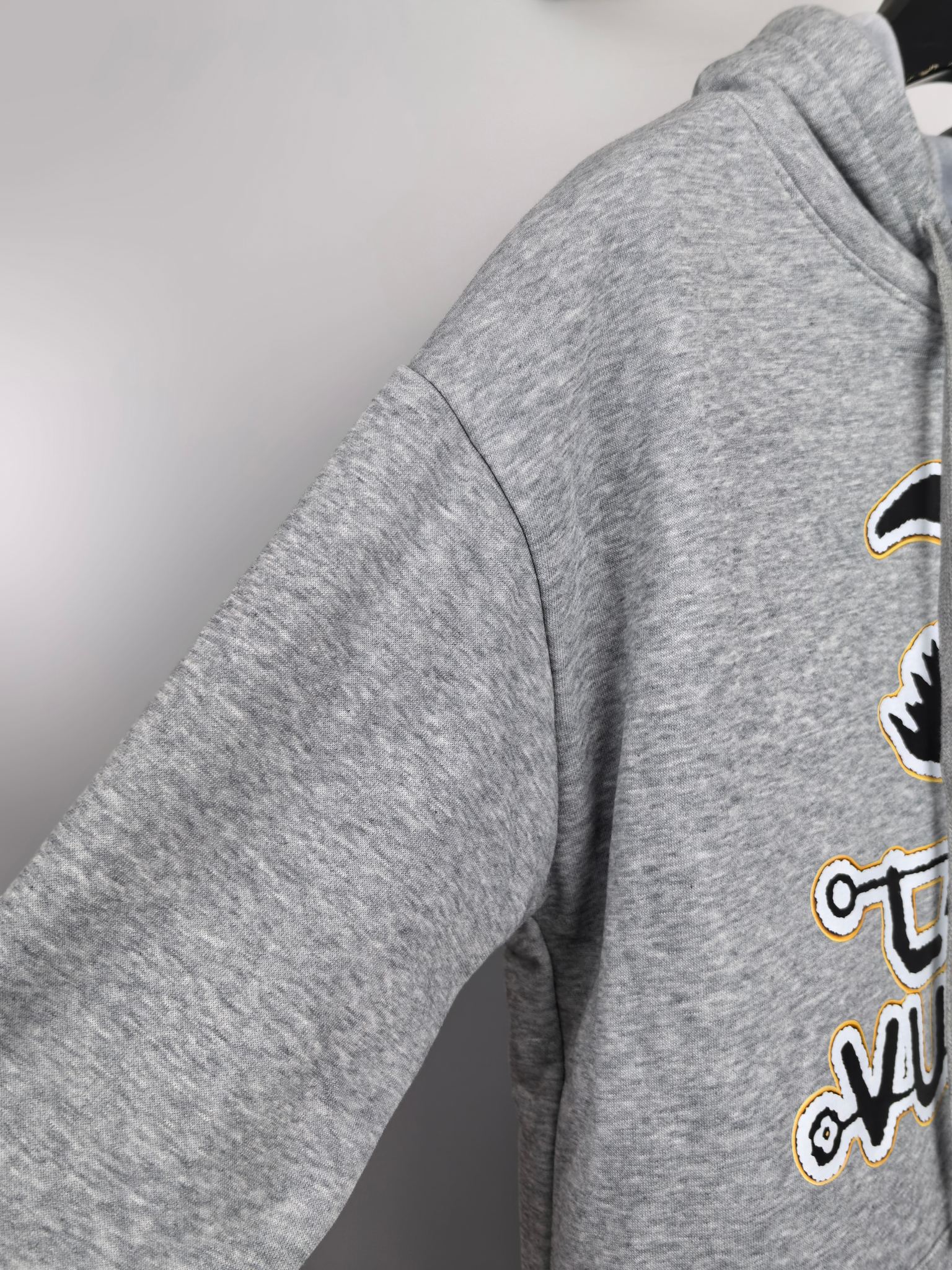 Gray kids hoodie showing side sleeve seam and partial Louis Vuitton graphic