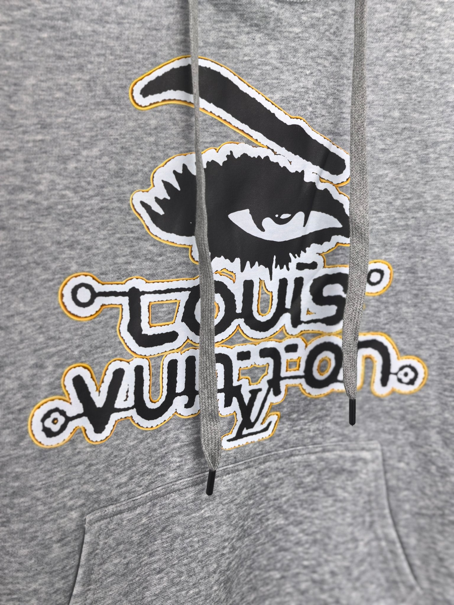 Gray kids hoodie close-up of front graphic print with bold Louis Vuitton emblem