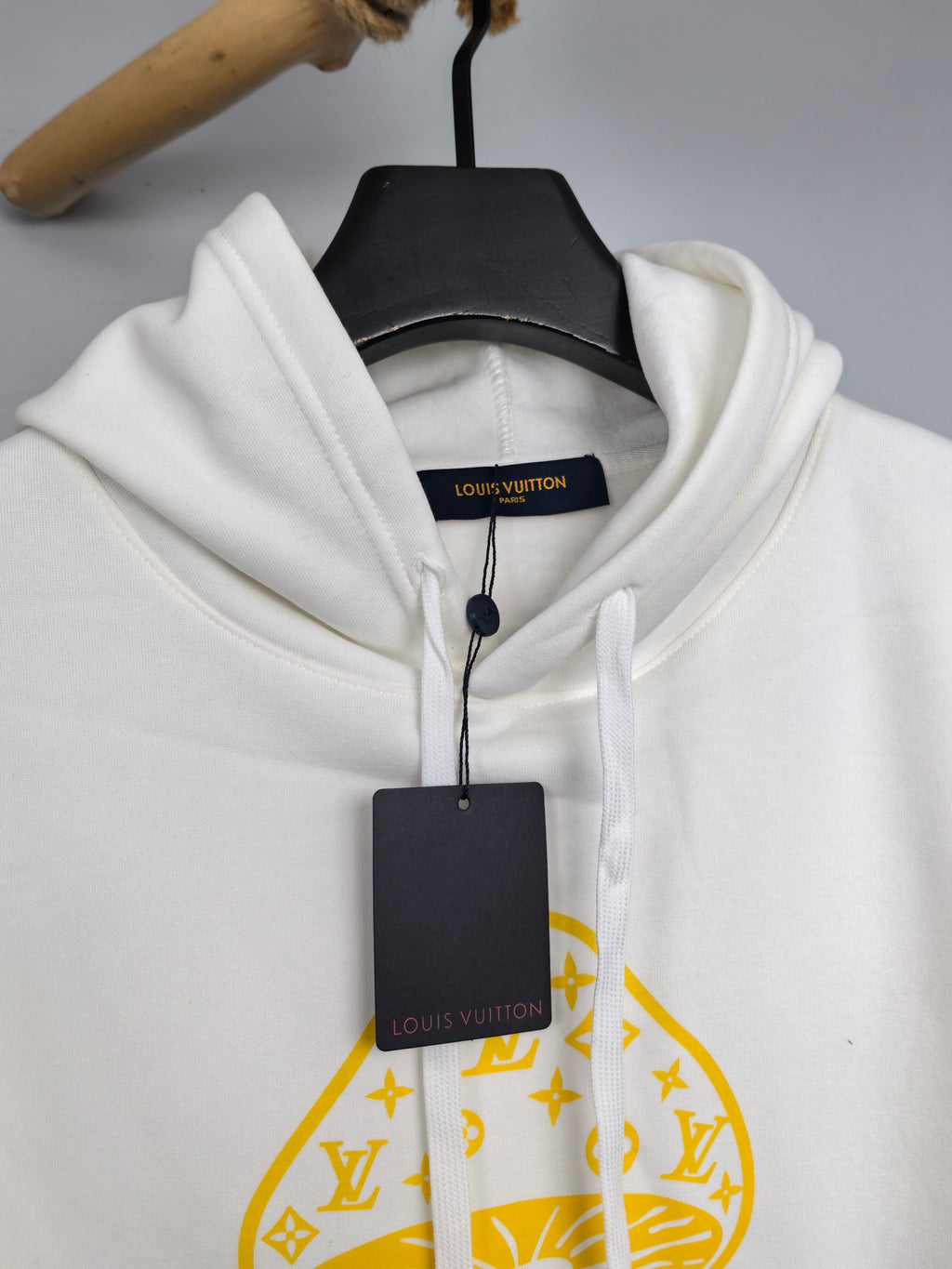 White hoodie with hood drawstrings and Louis Vuitton neckline label