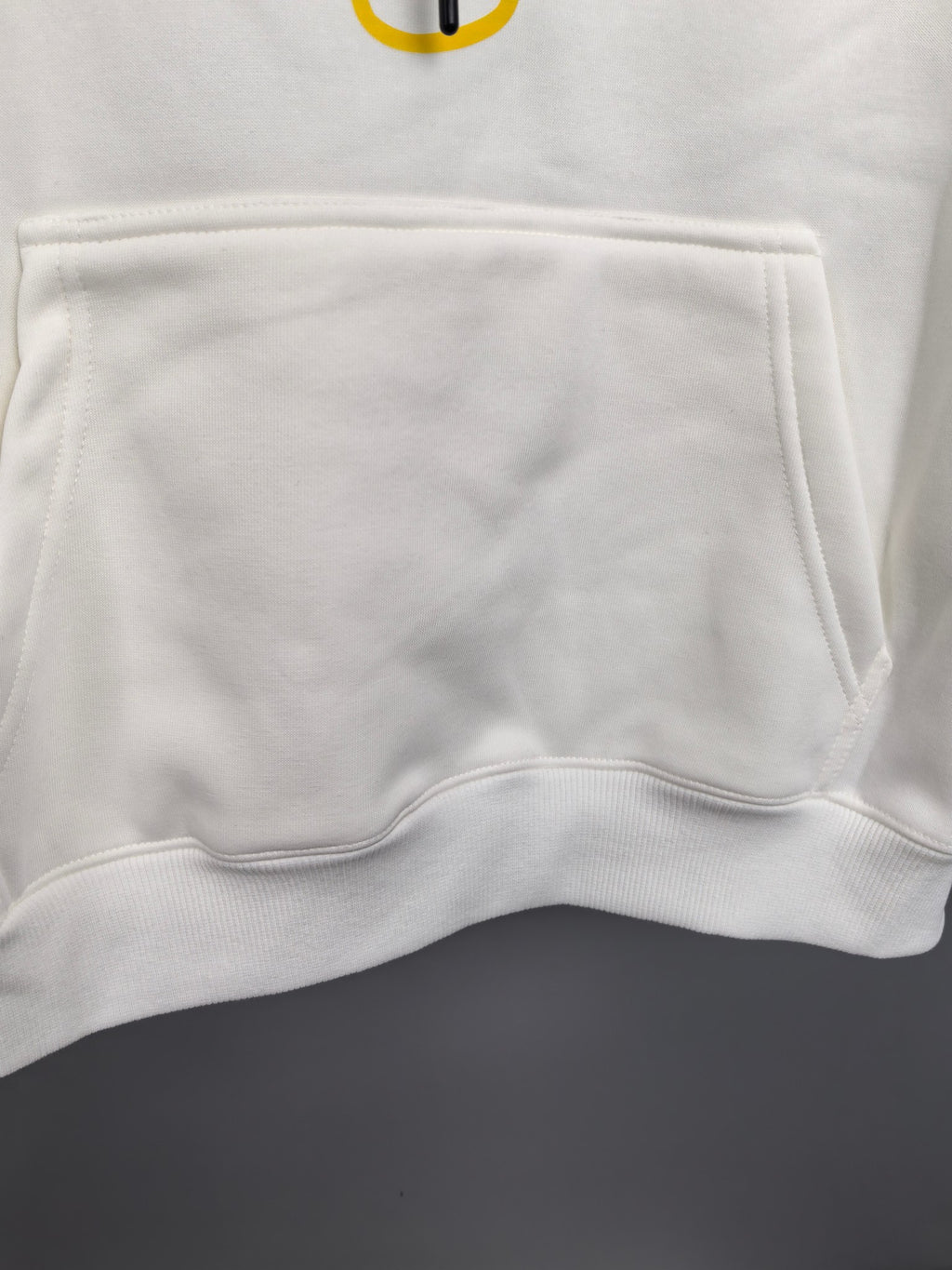 White hoodie kangaroo pocket with stitched hem detail
