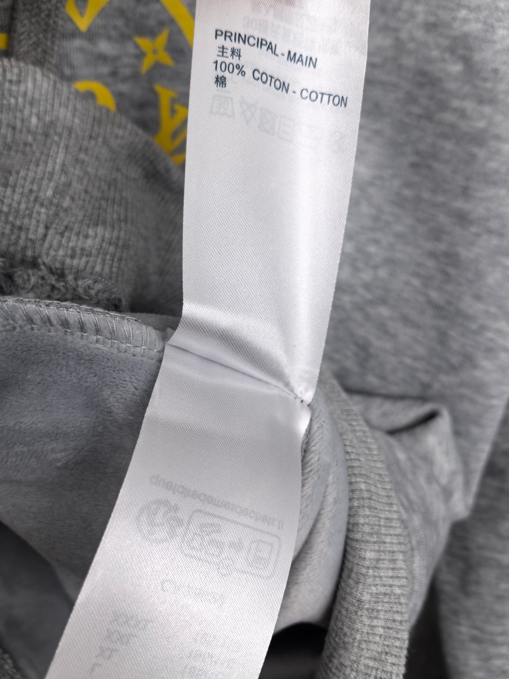 Gray hoodie fabric label reading '100% cotton'