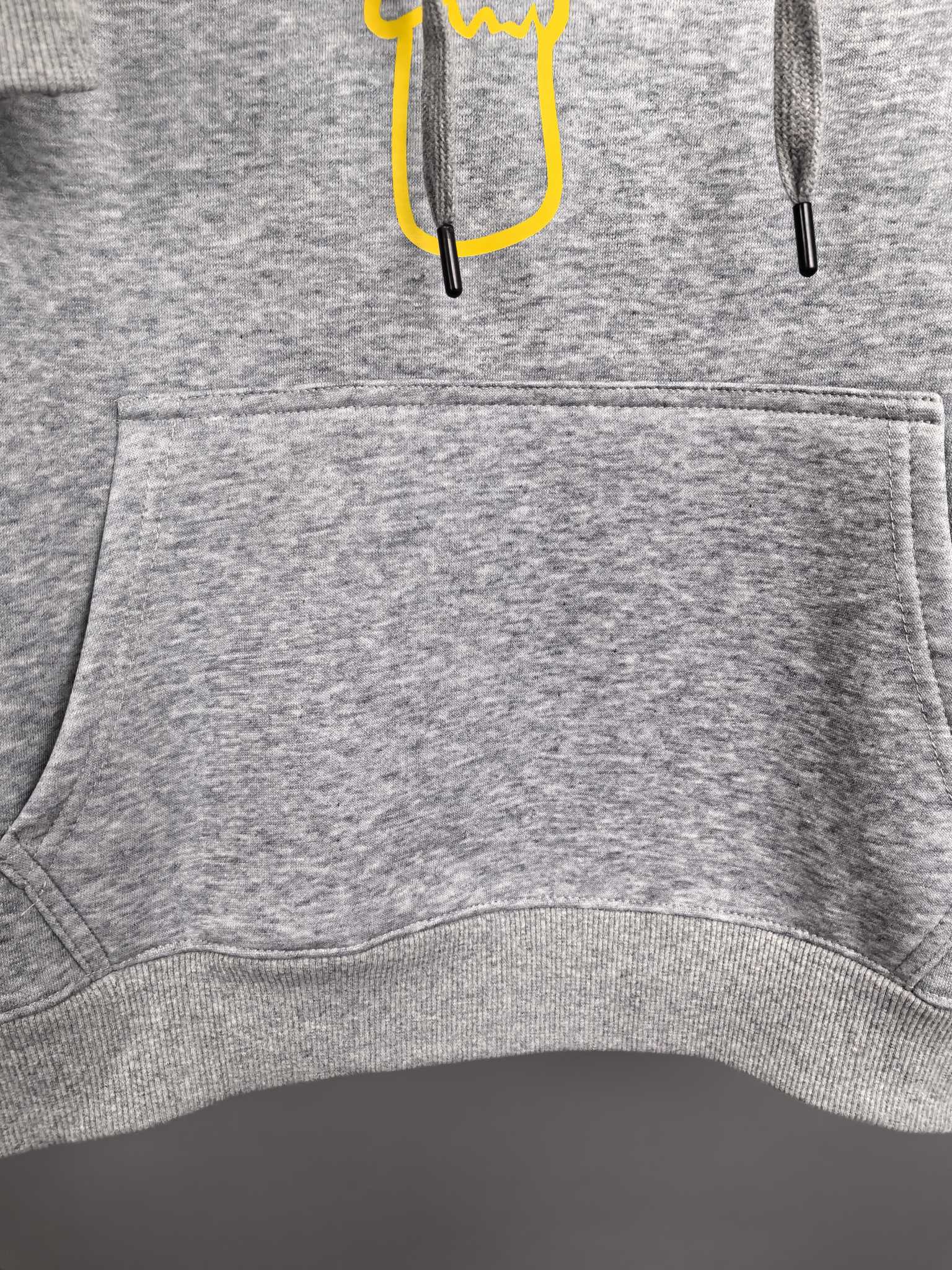 Gray hoodie front pocket and ribbed hem with drawstring ends
