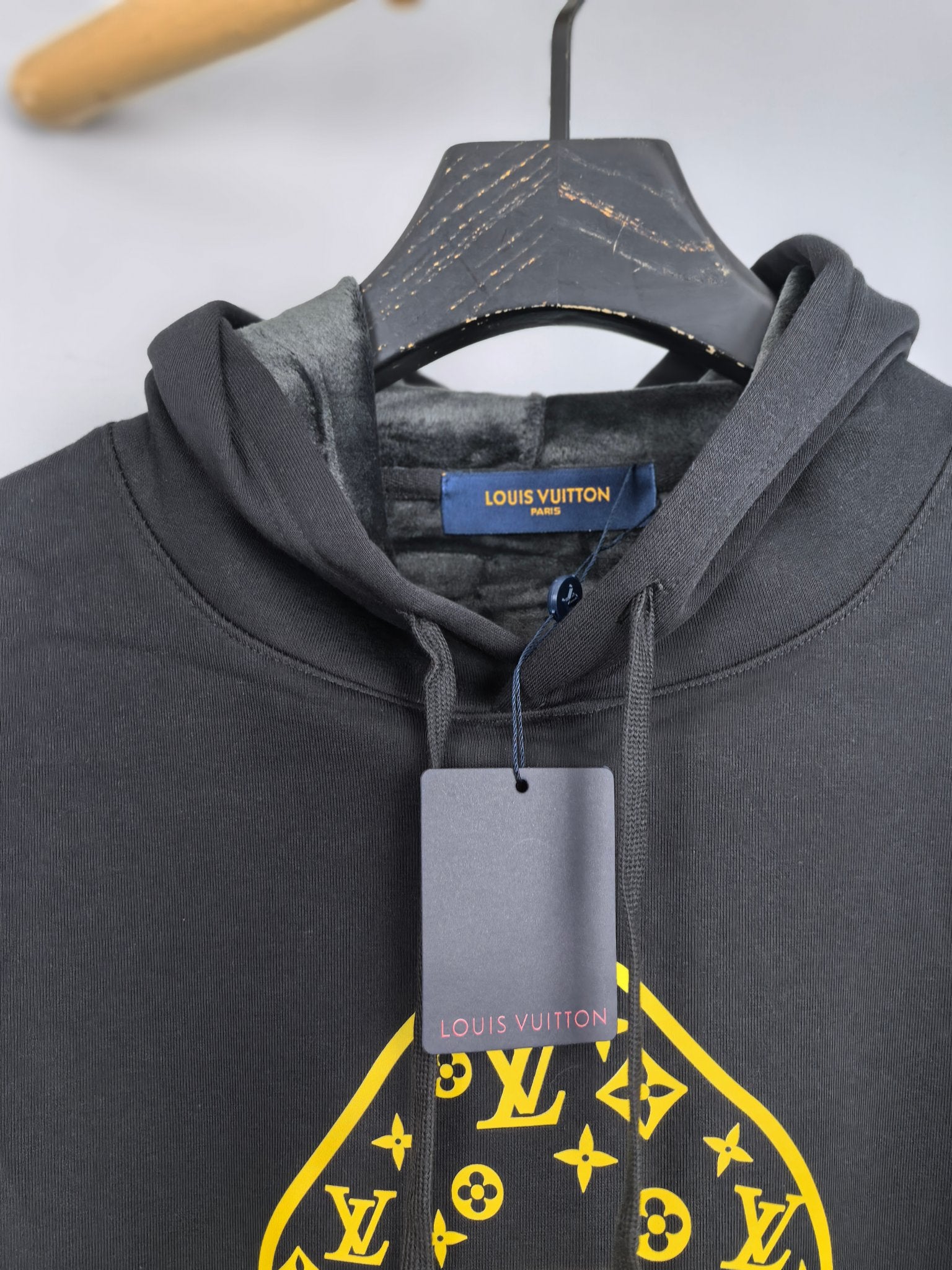 Louis Vuitton hooded sweatshirt neckline close-up with yellow graphic and brand tag