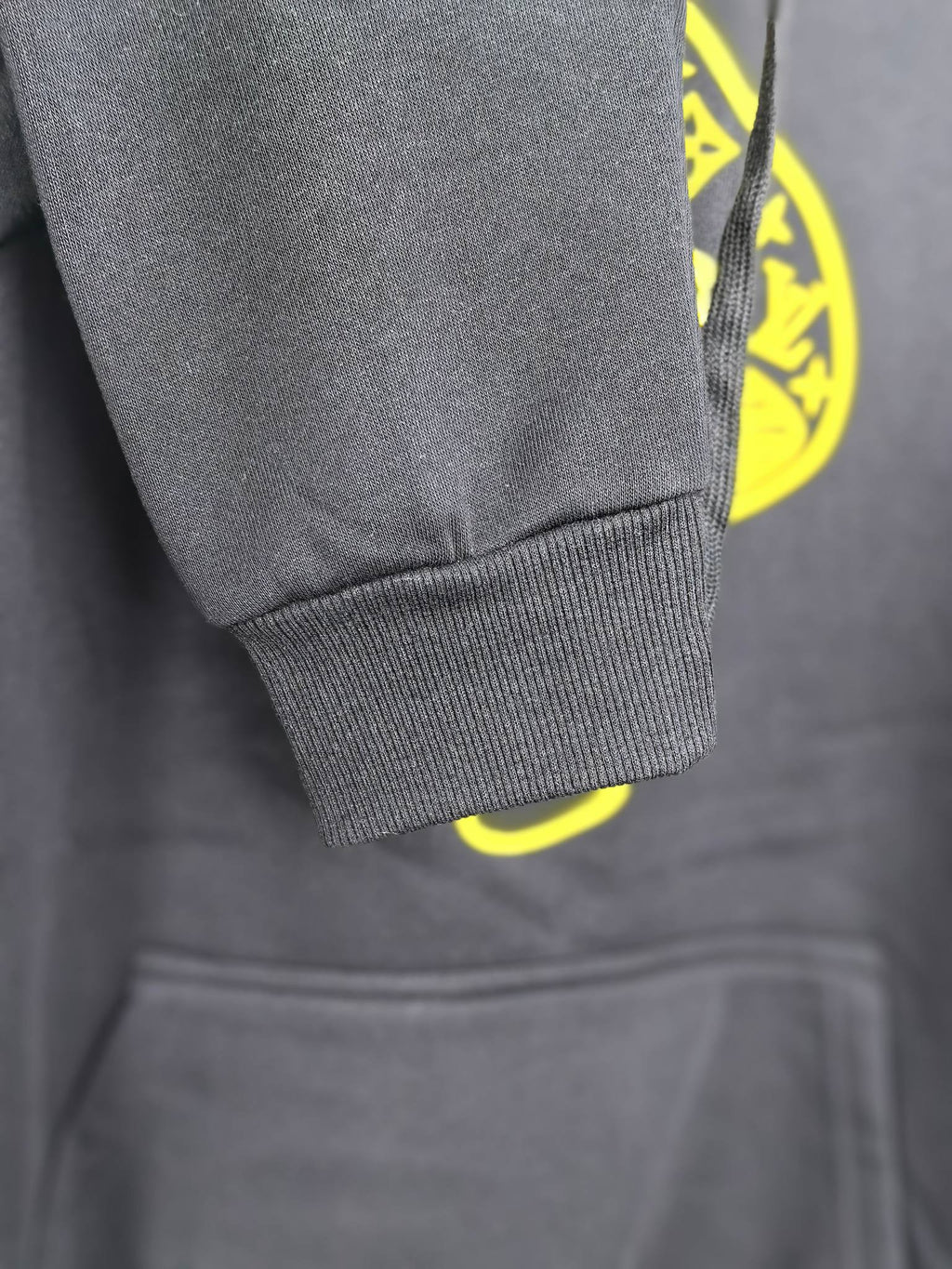 Dark gray sweatshirt sleeve cuff and front pocket seam detail