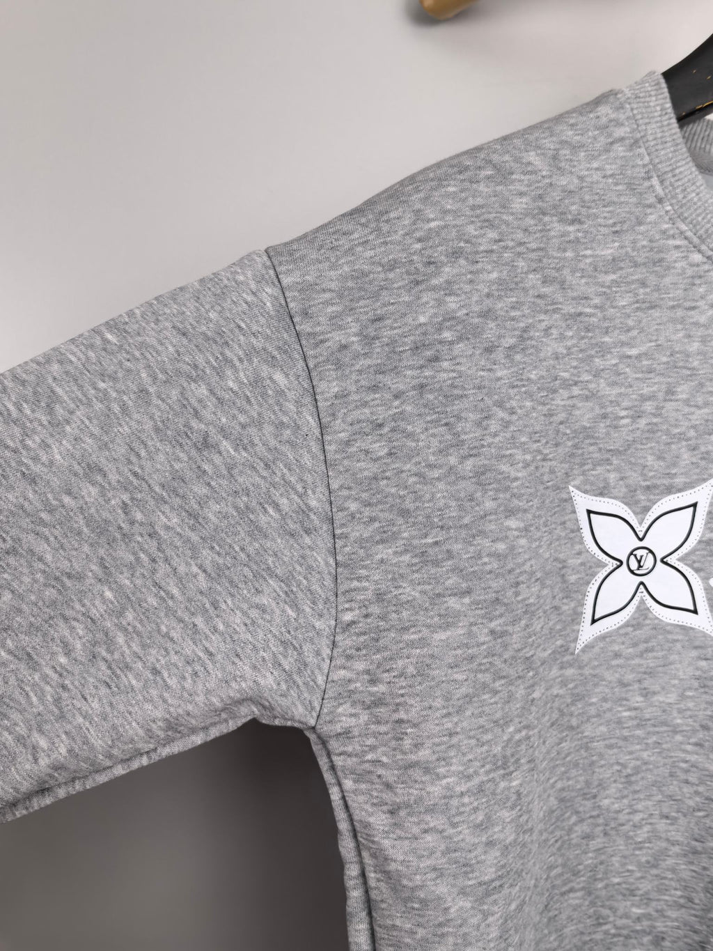 Heather gray sweatshirt sleeve with small white star logo print