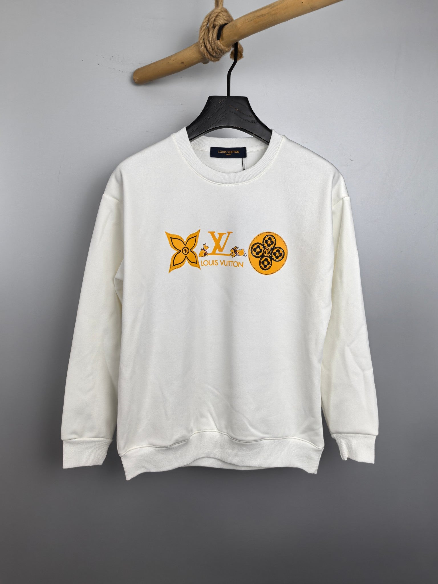 White crewneck sweatshirt with orange Louis Vuitton-style graphic on chest