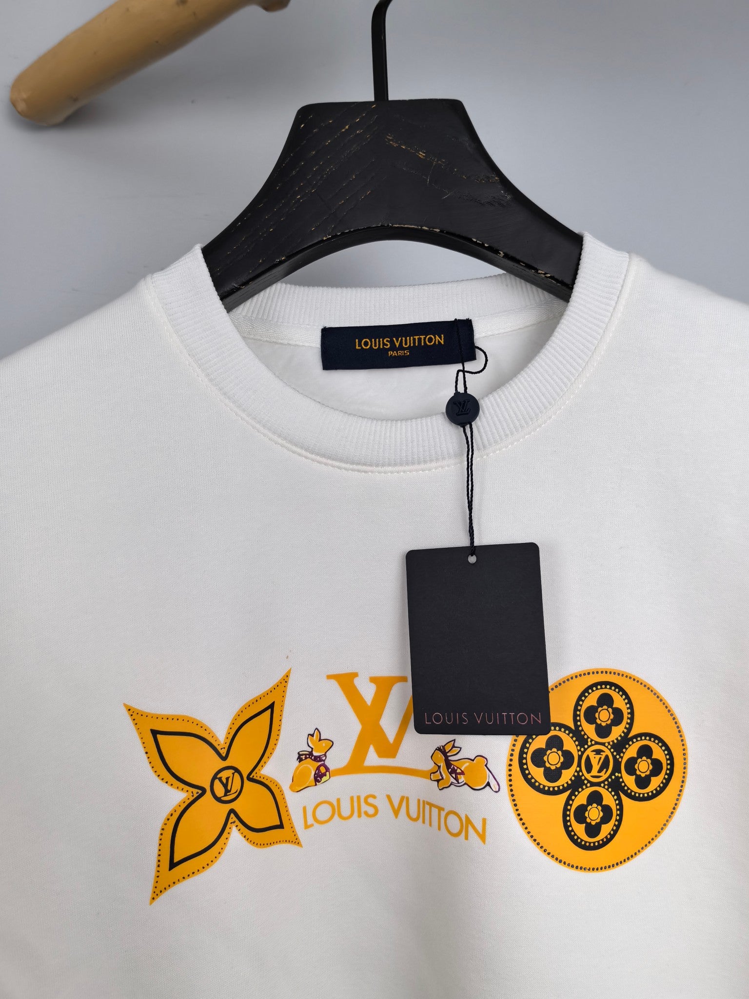 White crewneck sweatshirt neckline with orange Louis Vuitton logo graphic