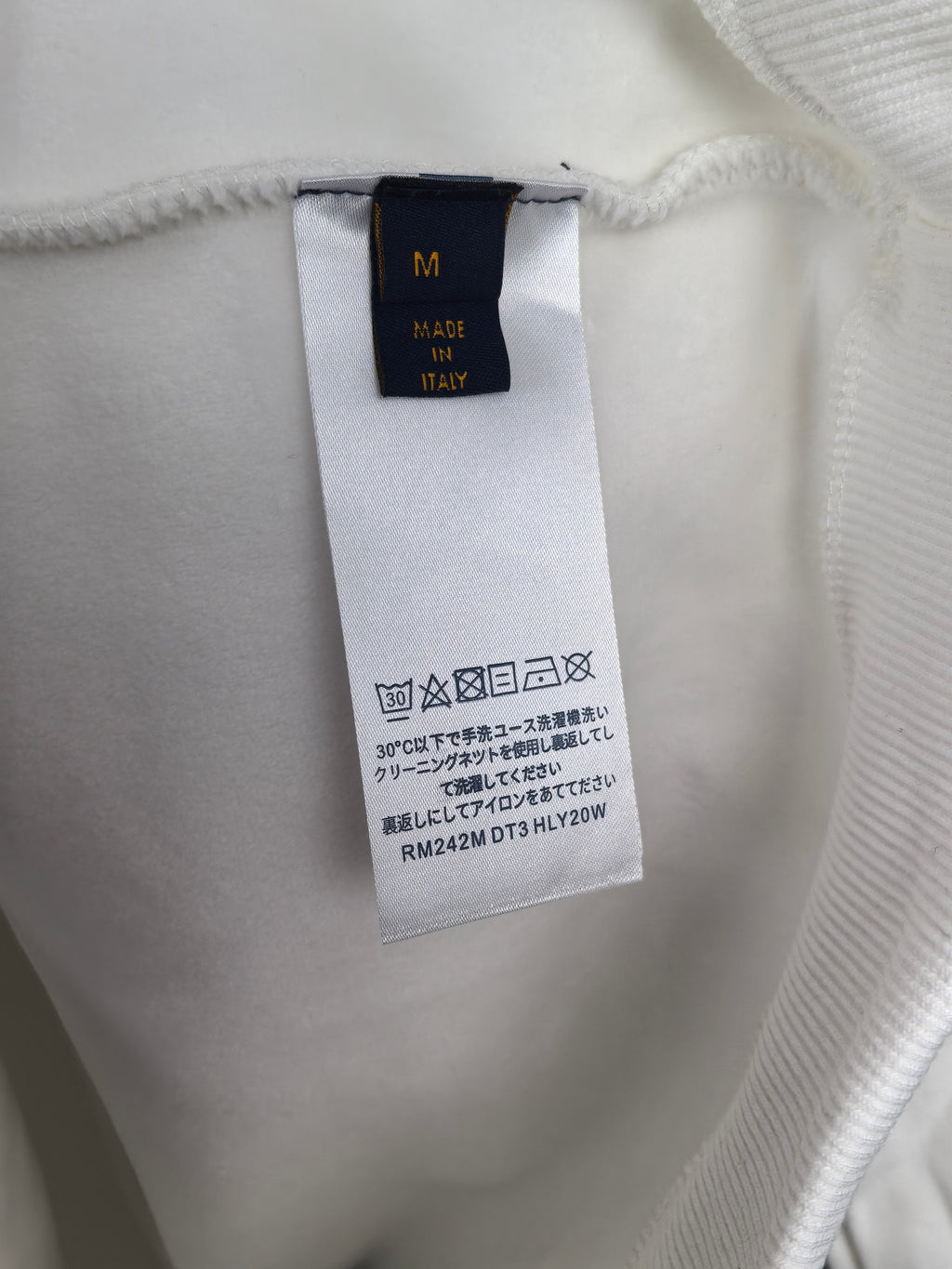 White sweatshirt with inside neck tag showing size and Made in Italy