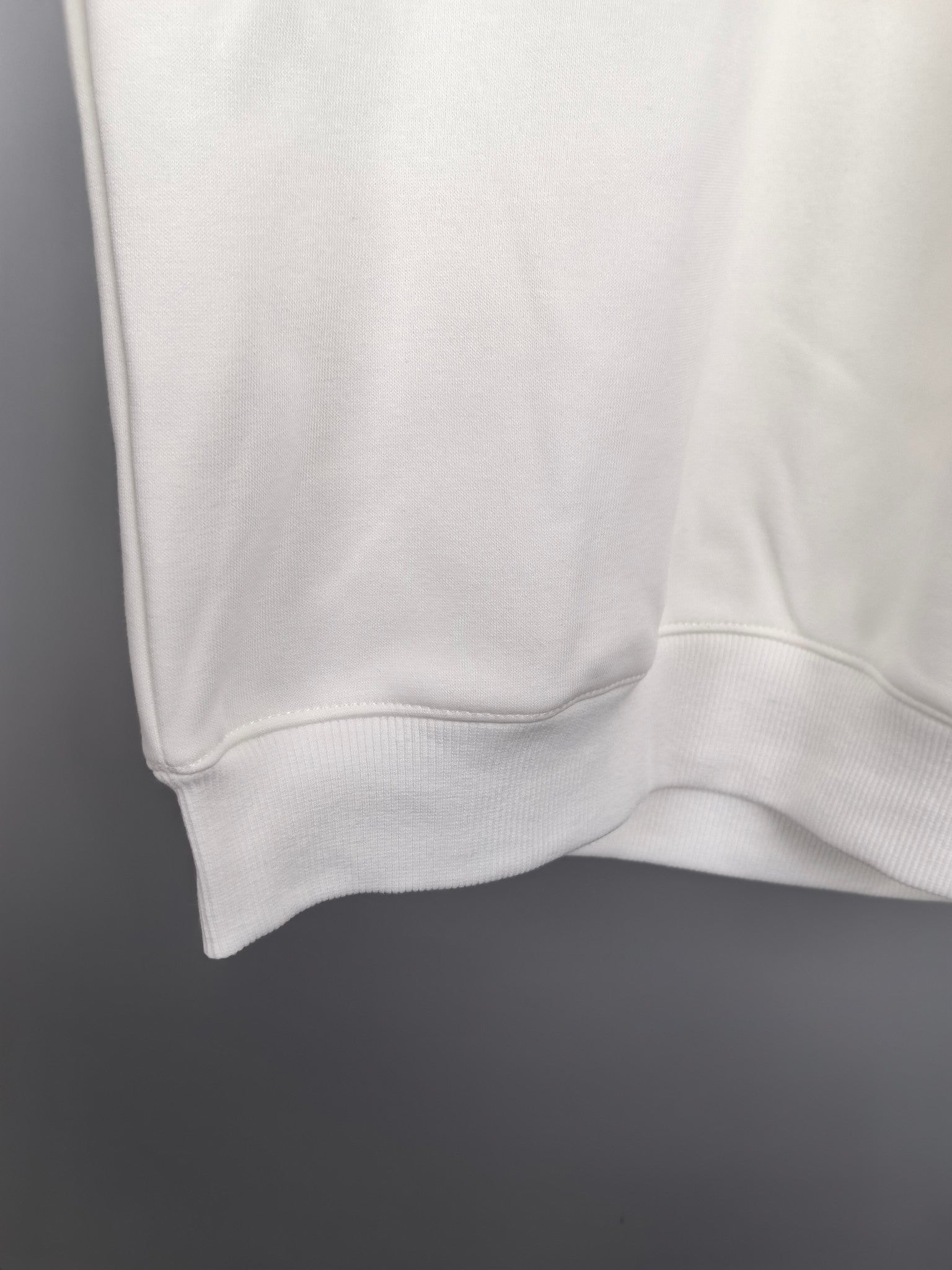 White sweatshirt lower hem with ribbed cuff detail