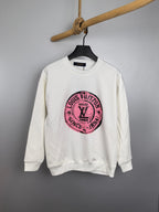 White long-sleeve sweatshirt with pink Louis Vuitton circular logo on chest