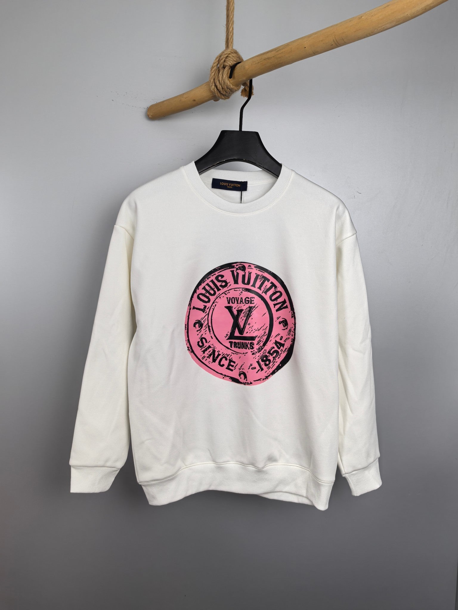 White long-sleeve sweatshirt with pink Louis Vuitton circular logo on chest