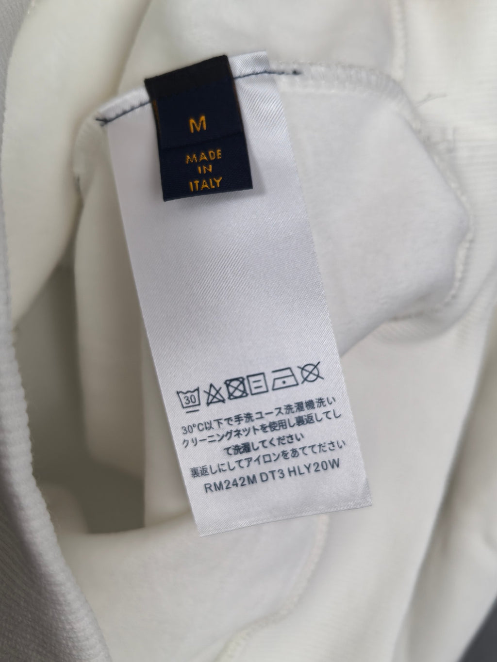 White sweatshirt care label and size tag, made in Italy