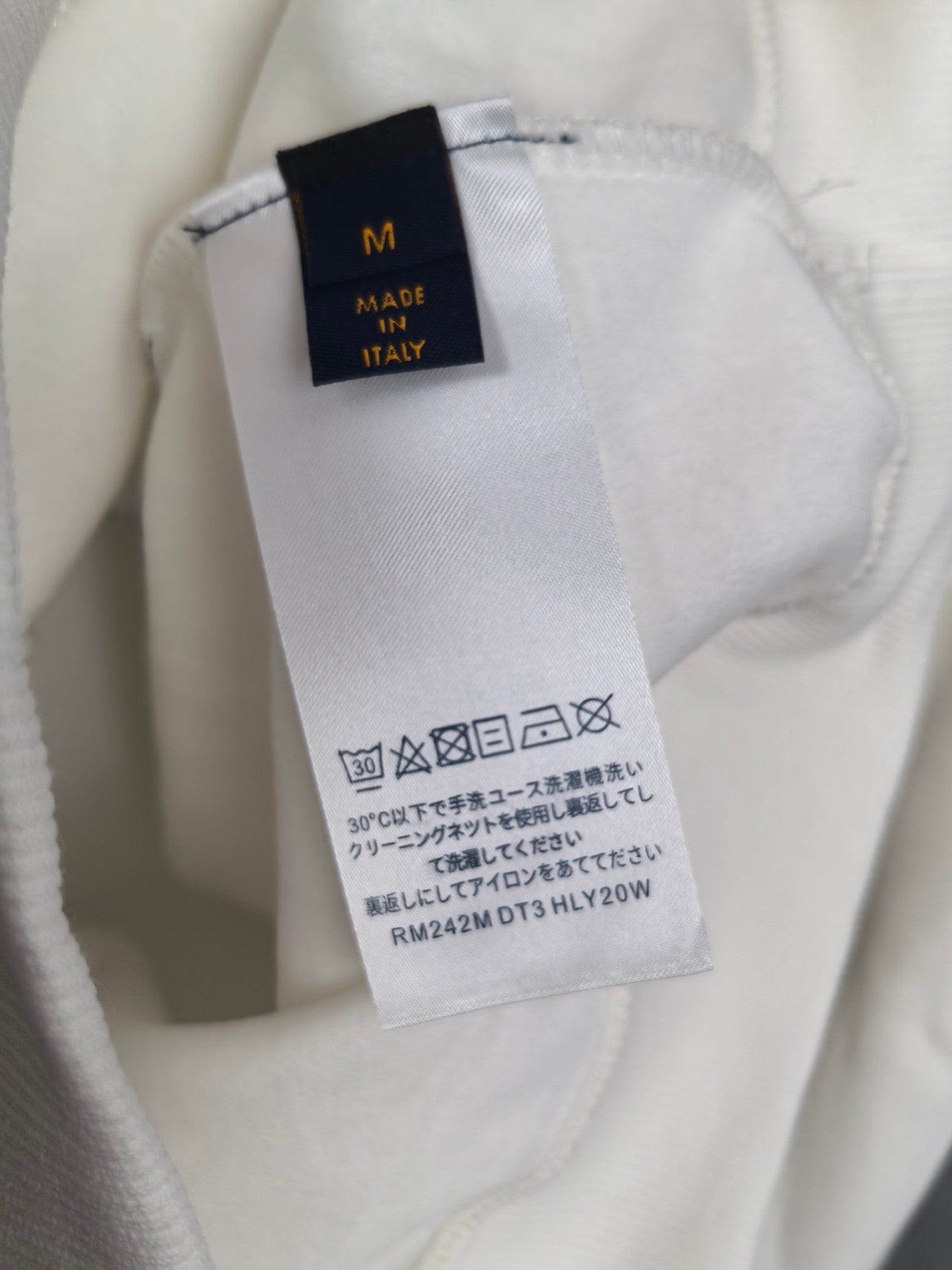 White sweatshirt care label and size tag, made in Italy