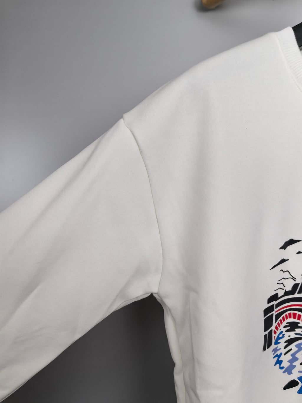 White sweatshirt sleeve with partial graphic print on side
