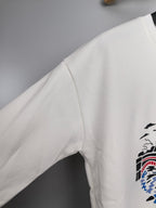 White sweatshirt sleeve with partial graphic print on side