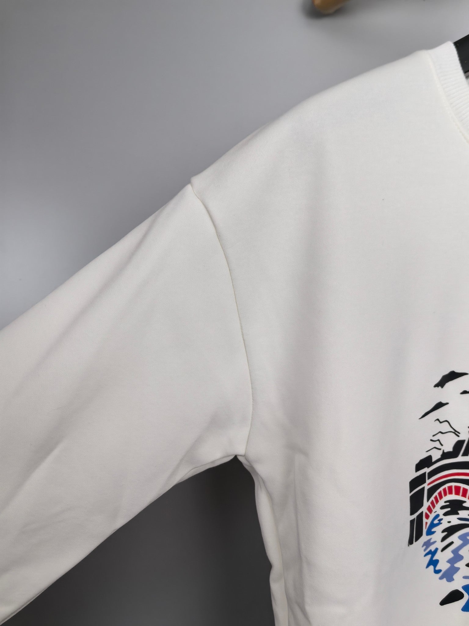 White sweatshirt sleeve with partial graphic print on side