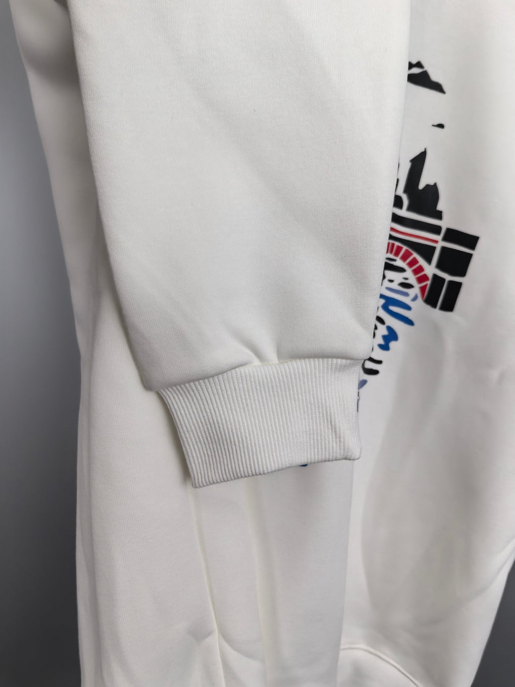 White sweatshirt hem and ribbed cuff detail on long sleeve