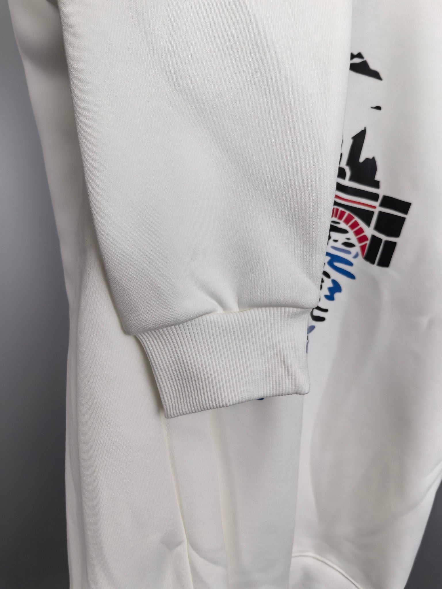 White sweatshirt hem and ribbed cuff detail on long sleeve
