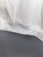 White sweatshirt ribbed hem and stitched seam close-up