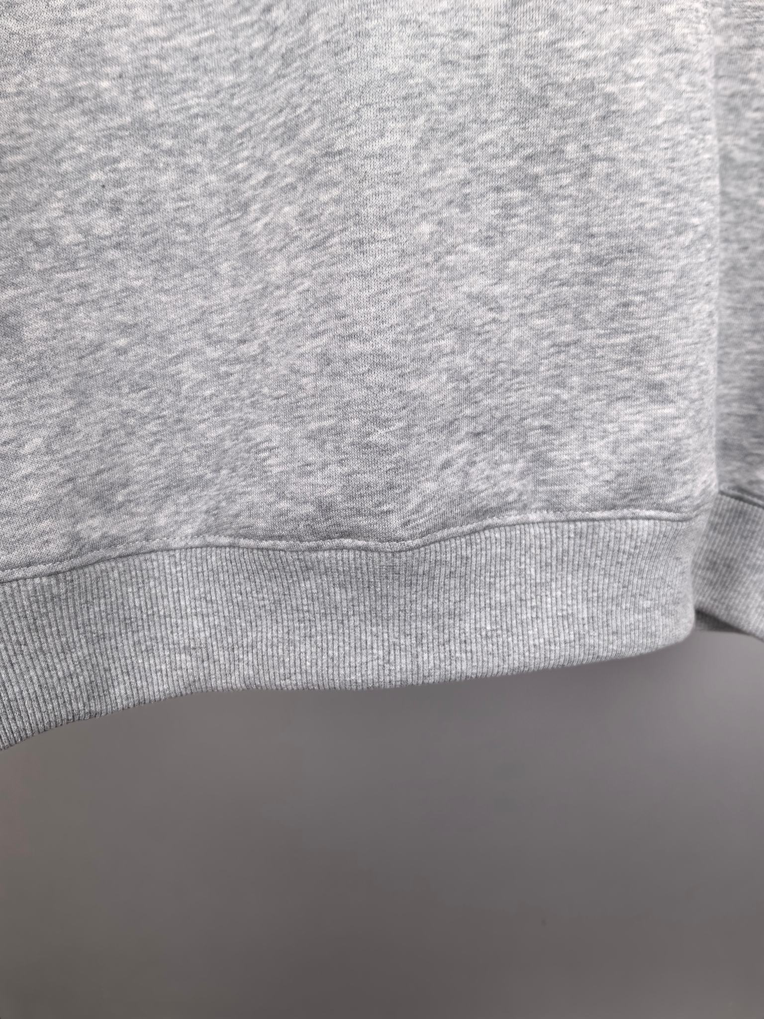 Grey crewneck sweatshirt cuff and lower hem detail
