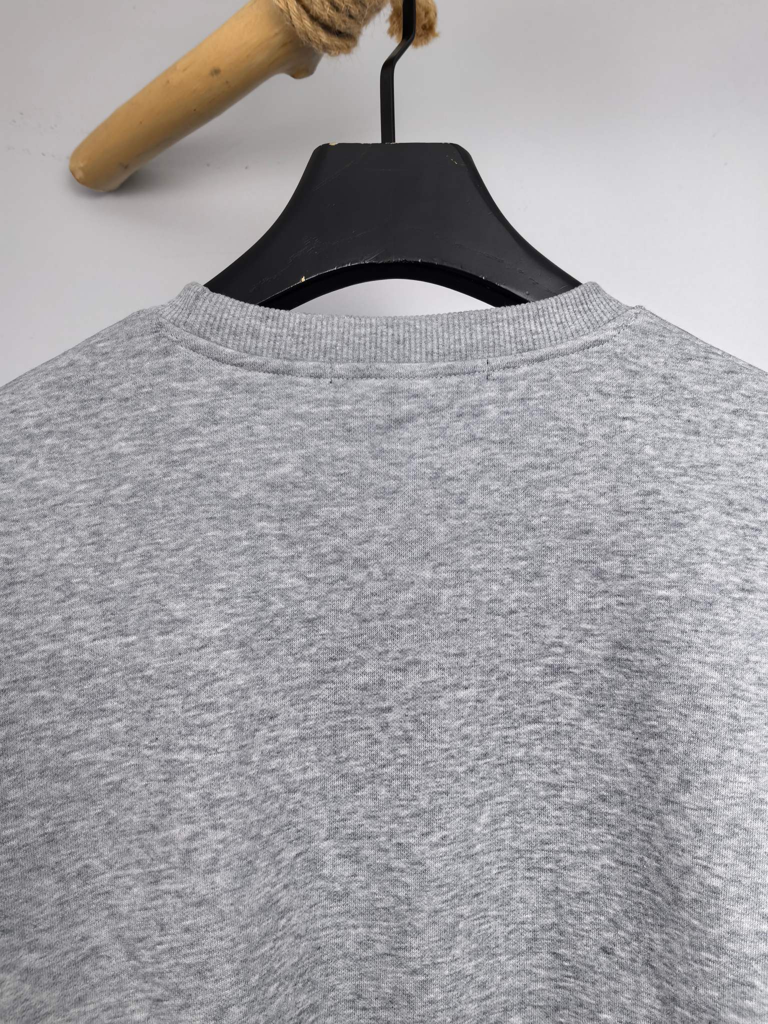 Grey crewneck sweatshirt back view on hanger