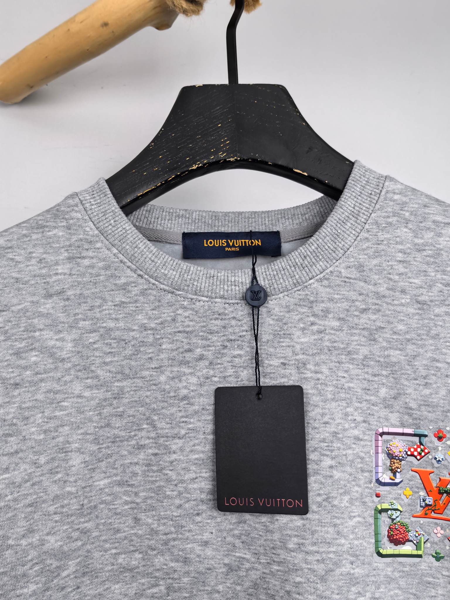 Gray crewneck sweatshirt neckline with inner brand label and hanging tags