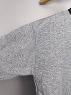 Gray long-sleeve sweatshirt with visible side seam and textured knit