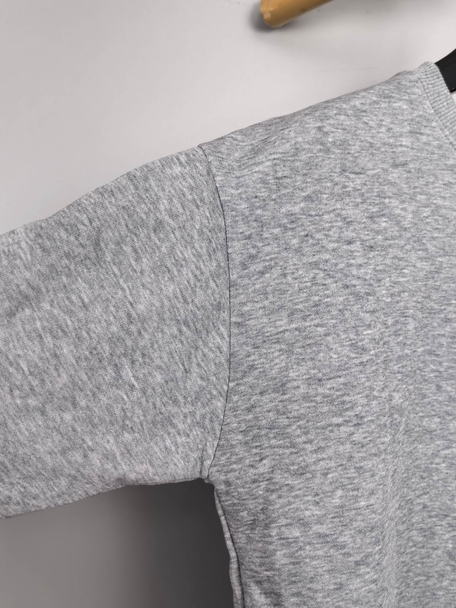 Gray long-sleeve sweatshirt with visible side seam and textured knit