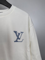 White sweatshirt with blue star-style LV logo on sleeve