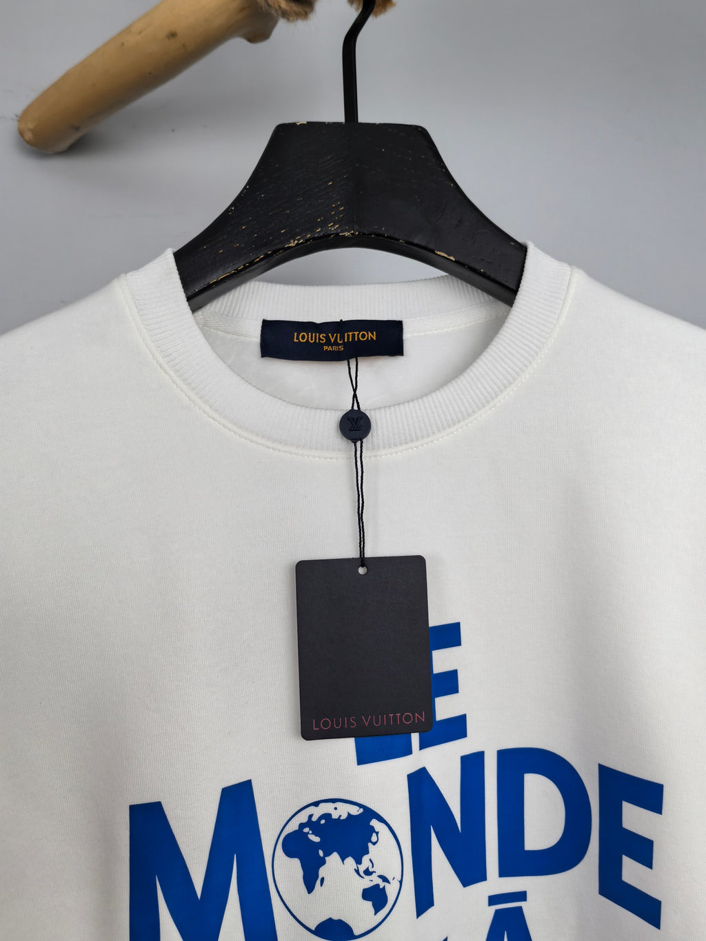 Louis Vuitton sweatshirt neckline close-up with “LE MONDE” blue graphic and tag