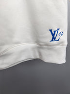 Louis Vuitton white sweatshirt lower sleeve area with small blue “LV” logo