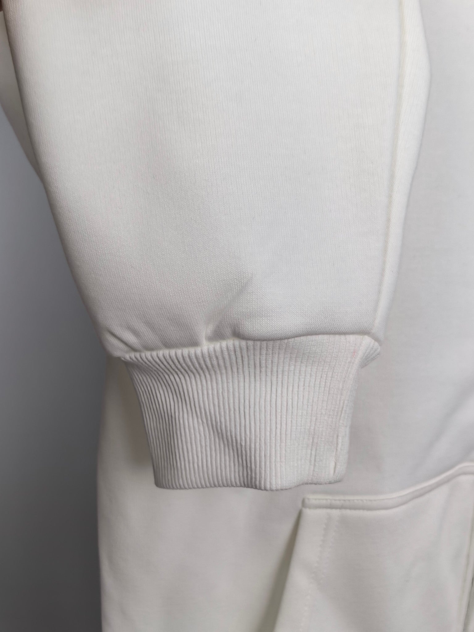 White hoodie hem with ribbed cuffs and stitched seam detail