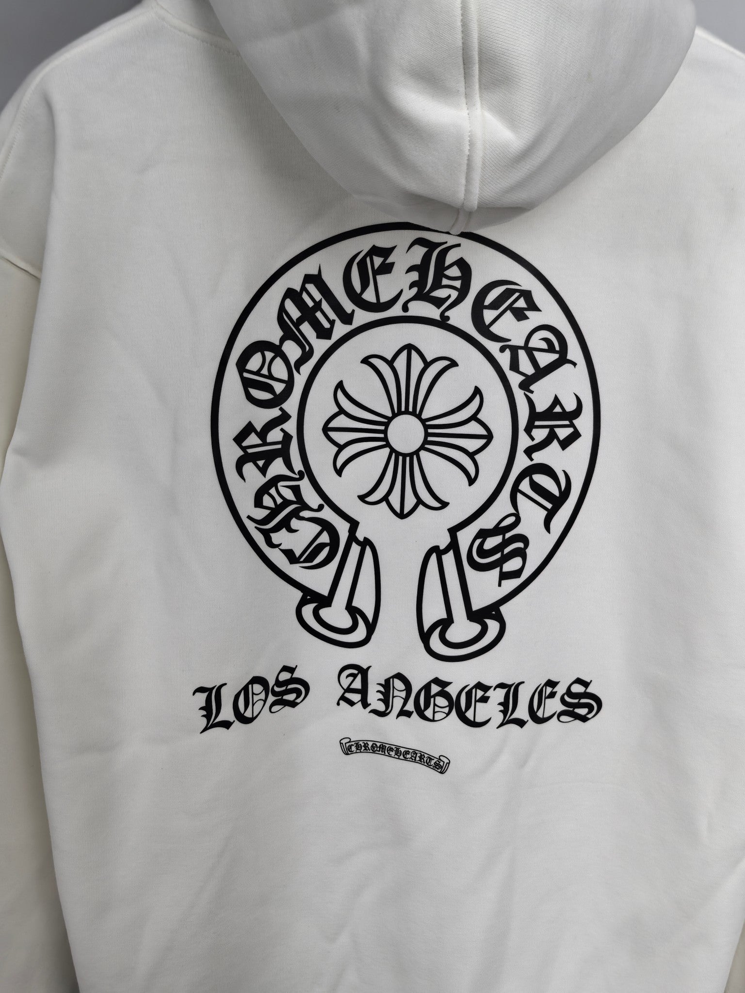 White hoodie front with large circular logo and “Los Angeles” lettering